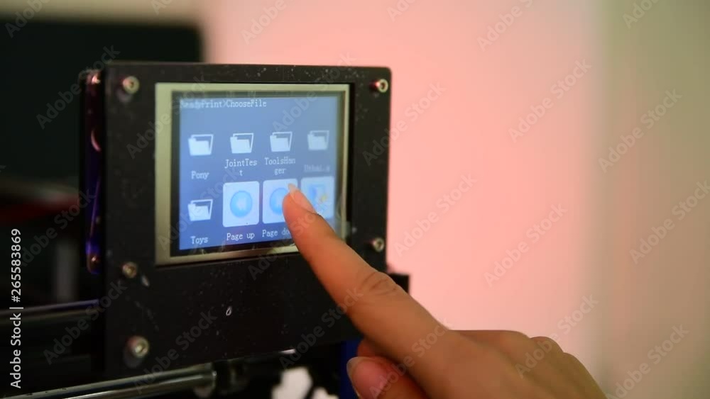 Woman finger press on screen to control 3D printer Woman finger press on screen to control 3D printer