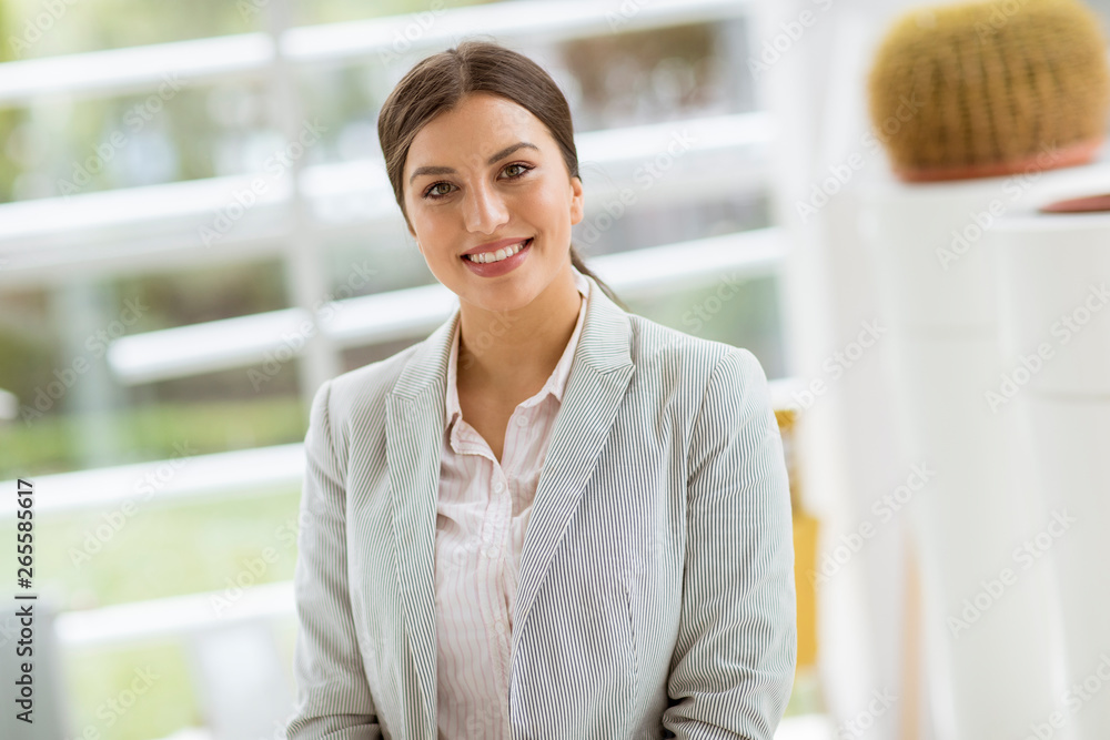 Portrait of young beautiful business woman standing in the office Portrait of young beautiful business woman standing in the office
