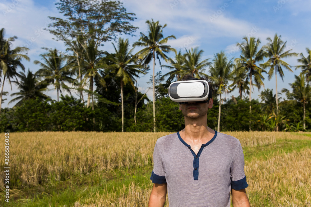 Young man with VR glasses in the tropical rice field Young man with VR glasses in the tropical rice field