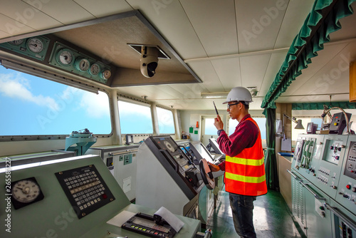 duty officer in charge handle of the ship navigating to the port destination, keep watching navigation on the bridge of the ship vessel under voyage sailing to the sea