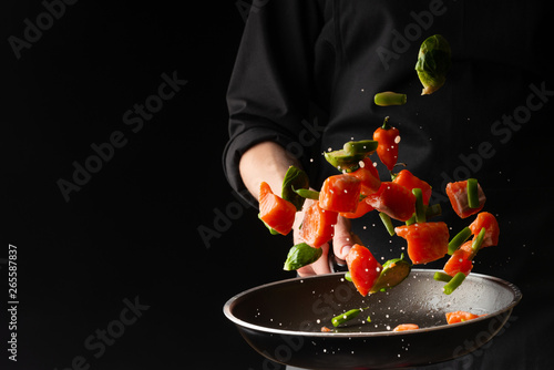 Professional cook prepares pieces of red fish photo