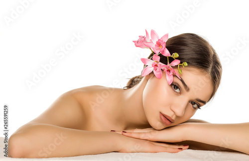Young woman with makeup posing with orchids on white background