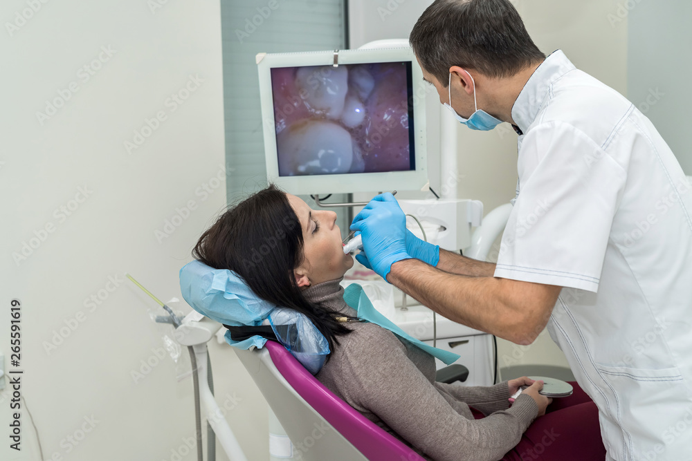 Dentist checking patient's teeth with camera in stomatology Dentist checking patient's teeth with camera in stomatology