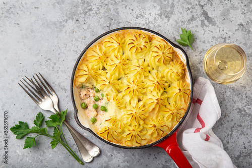 Salmon, mashed potatoes and vegetables casserole in enamel cast iron pan photo