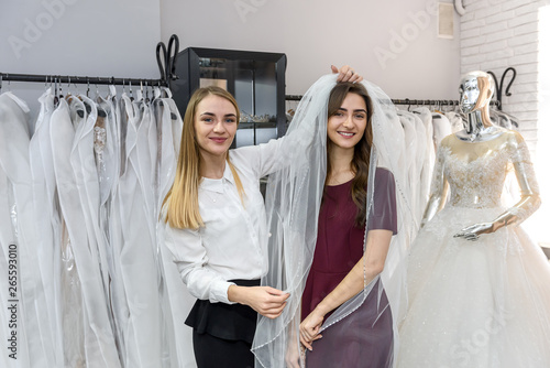 Young bride posing with veil in wedding salon