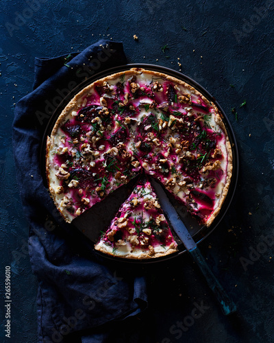 Top view on beetroot tart served on blue ceramic plate over textile napkin