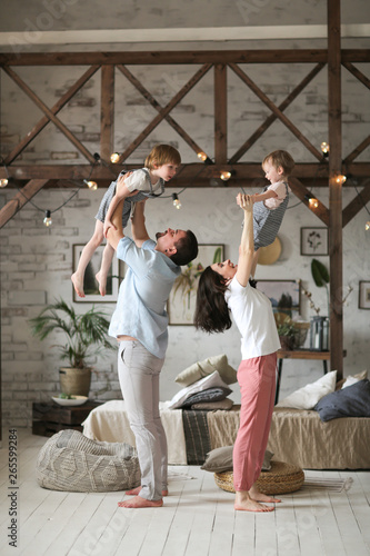 mom and dad hold children in air, casual home