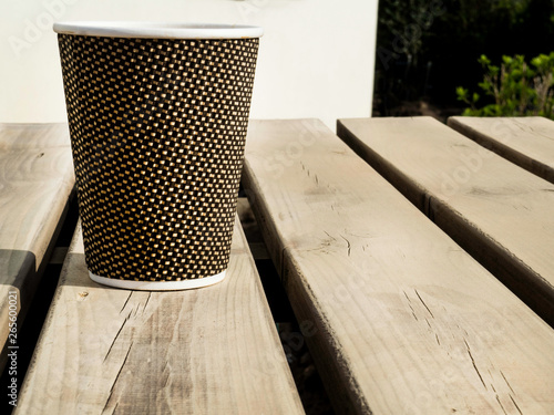 Cup of coffee to go on the wooden table. Street coffee.