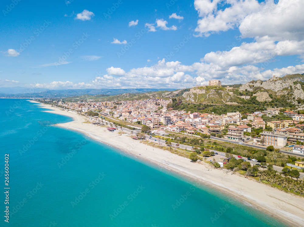 Vista aerea della città di Roccella Ionica o Jonica in Calabria, con il porto delle Grazie, il castello Carafa e la bellissima spiaggia sabbiosa con il mare Mediterraneo blu. 