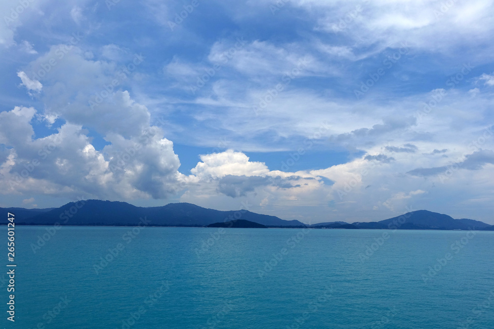 Blue sea and sky with white clouds