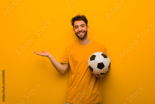 Young soccer player man holding something with hand
