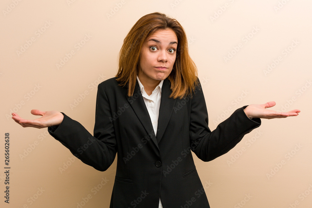 Young caucasian business woman doubting and shrugging her shoulders in questioning gesture. Young caucasian business woman doubting and shrugging her shoulders in questioning gesture.