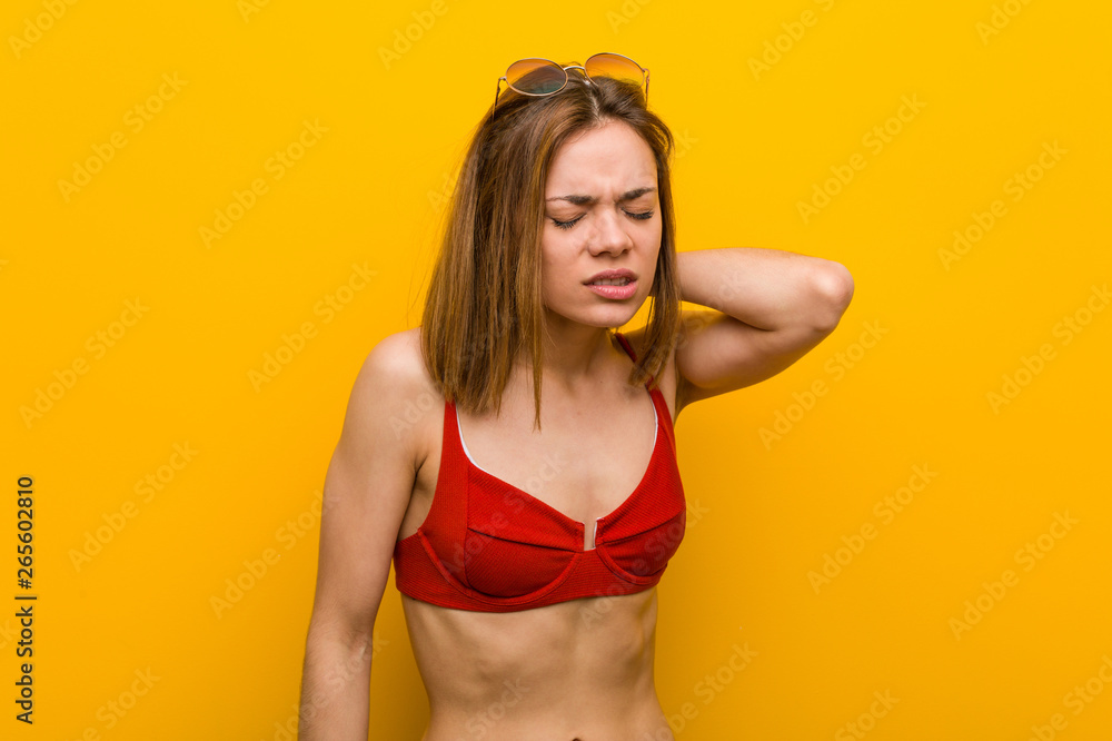 Young caucasian woman wearing bikini and sunglasses suffering neck pain due to sedentary lifestyle. Young caucasian woman wearing bikini and sunglasses suffering neck pain due to sedentary lifestyle.