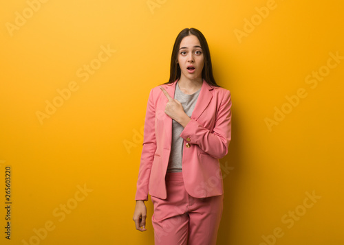 Young modern business woman pointing to the side © Asier