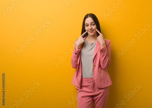 Young modern business woman smiles, pointing mouth