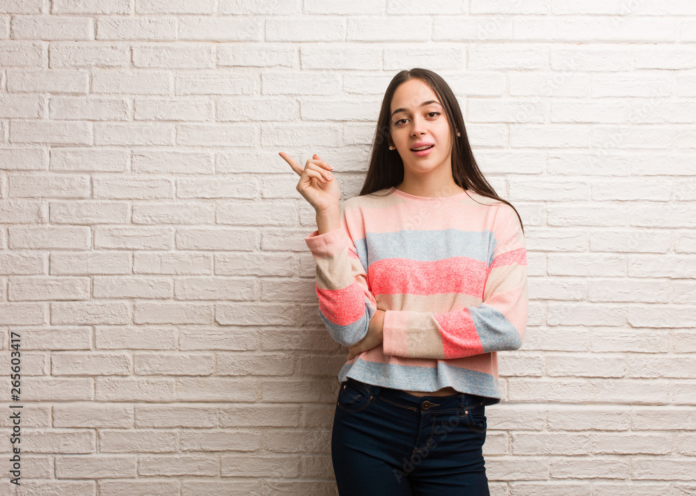 Young modern woman pointing to the side with finger Young modern woman pointing to the side with finger
