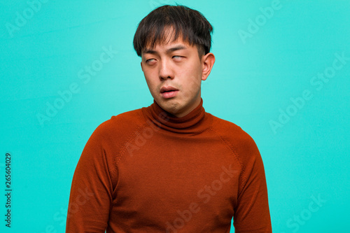 Quadro em tela Young chinese man tired and bored