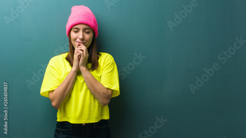 Young modern woman praying very happy and confident