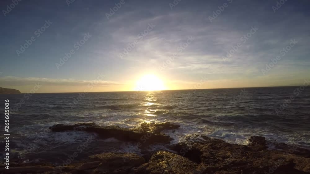 puesta de sol sobre una playa de mallora con olas rompiendo en la orilla puesta de sol sobre una playa de mallora con olas rompiendo en la orilla