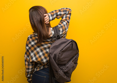 Young student woman from behind thinking about something