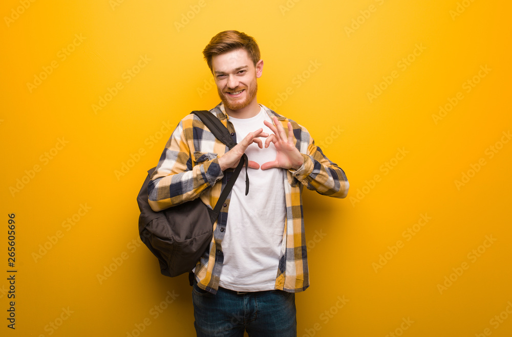 Young redhead student man doing a heart shape with hands Young redhead student man doing a heart shape with hands