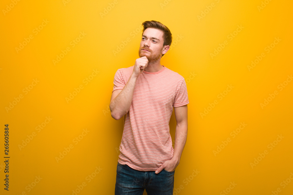 Young redhead man doubting and confused