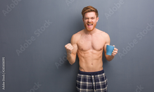 Young shirtless redhead man surprised and shocked. He is holding a coffee mug.