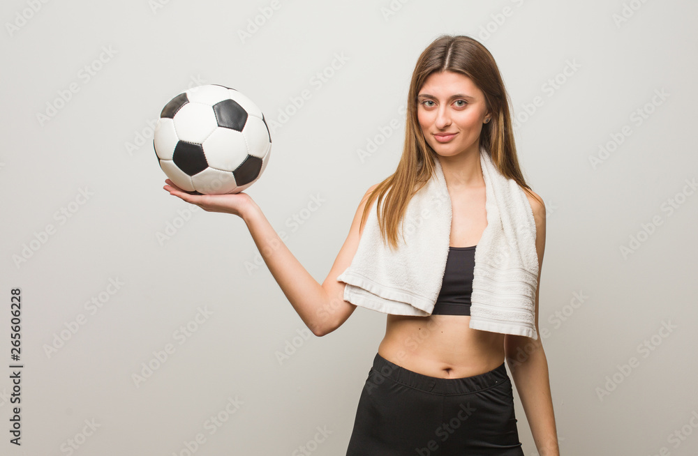Young fitness russian woman holding something with hand. Holding a soccer ball.