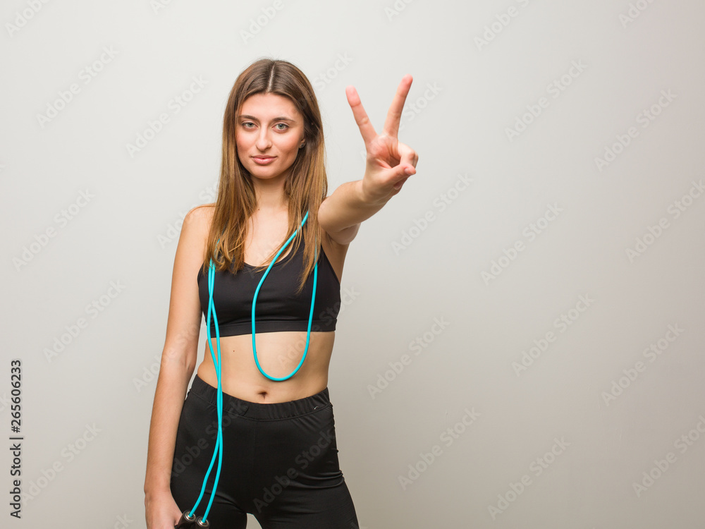 Young fitness russian woman showing number two. Holding a jump rope. Young fitness russian woman showing number two. Holding a jump rope.