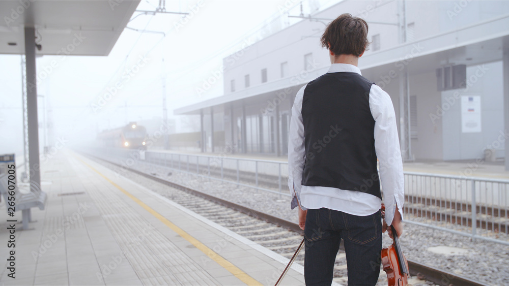Violin musician wait for the train Violin musician wait for the train