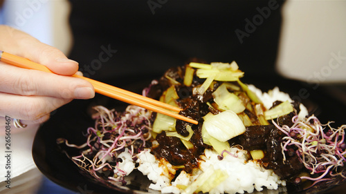 Eating chinese rice dish with sticks photo