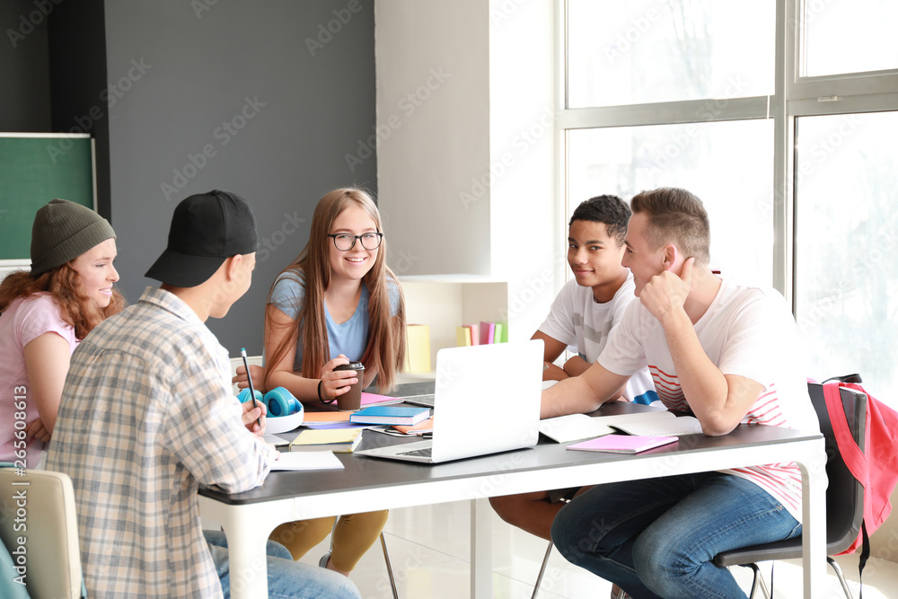 Group of teenagers studying together in school