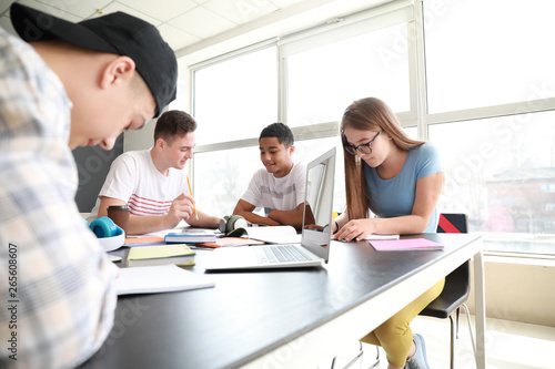 Group of teenagers studying together in school