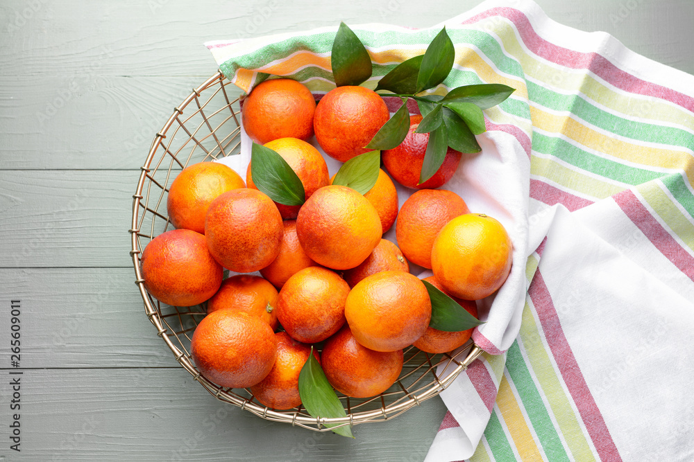 Basket with fresh blood oranges on wooden table Basket with fresh blood oranges on wooden table