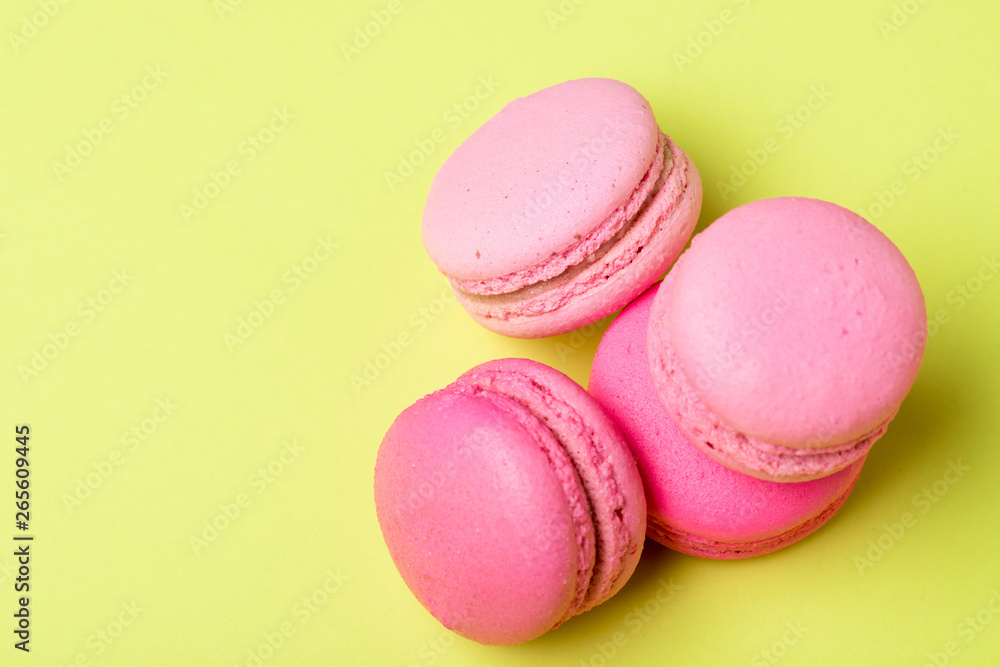 tasty pink macarons with filling on yellow surface tasty pink macarons with filling on yellow surface