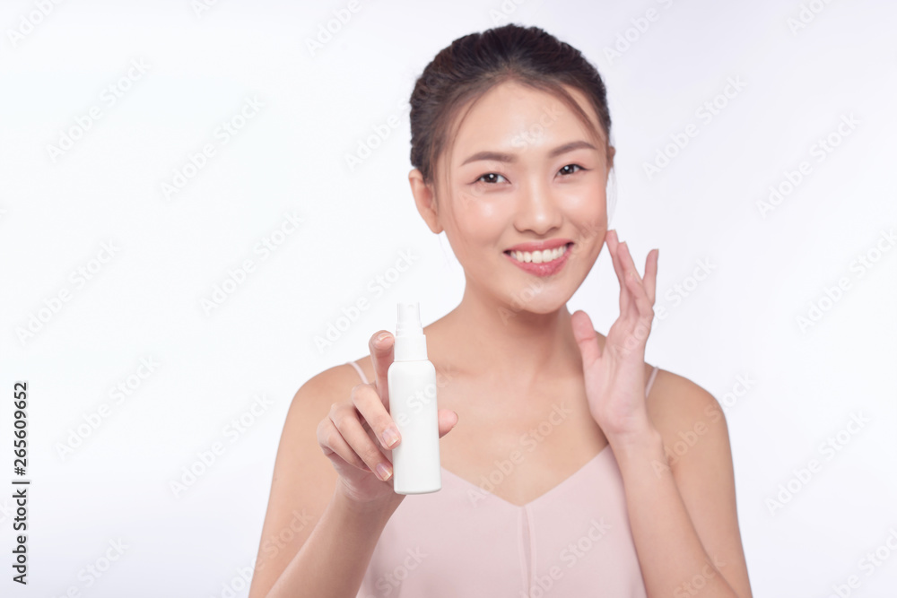 smiling young woman showing skincare products smiling young woman showing skincare products