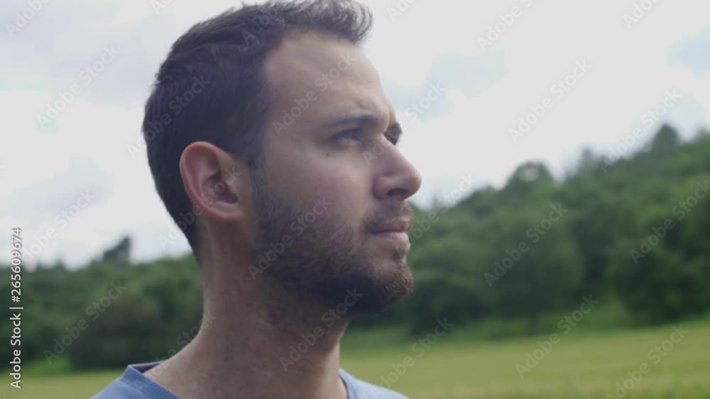 Close Up of man's face looking serious. Looking around. Surrounded by nature Close Up of man's face looking serious. Looking around. Surrounded by nature