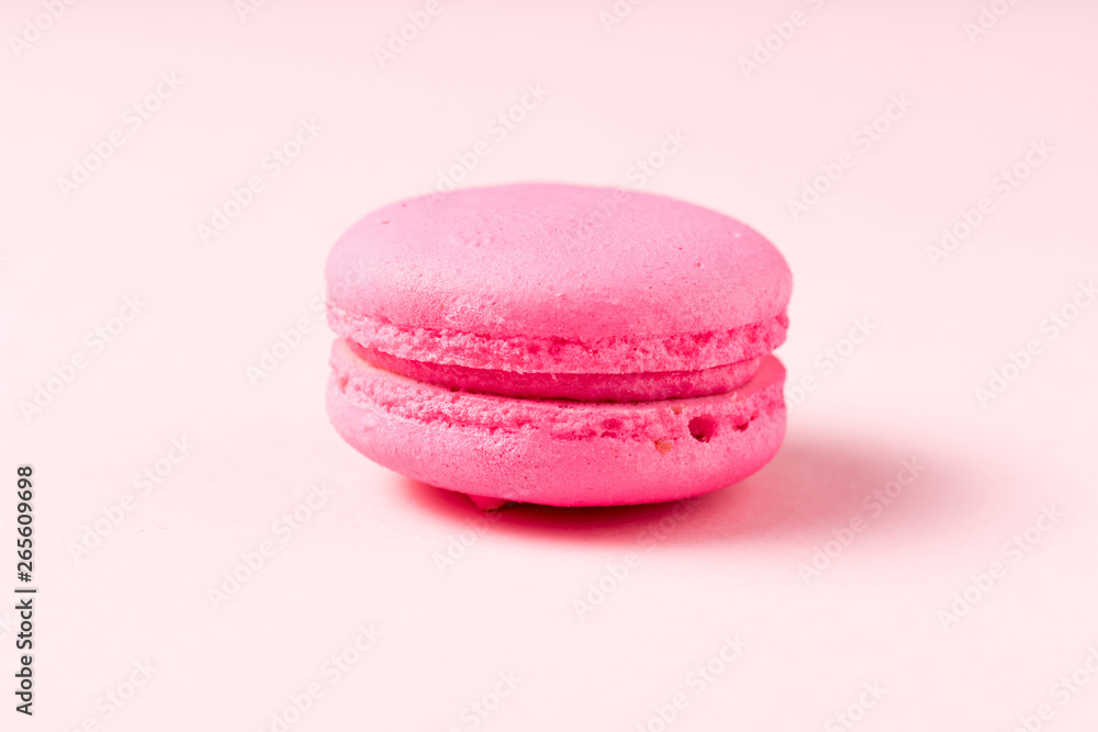 bright macaron cookie with filling on pink surface bright macaron cookie with filling on pink surface