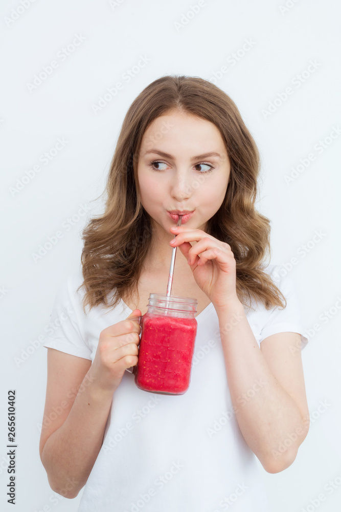 Beautiful happy young girl drinks organic berry, fruit smoothie on a white background. Beautiful happy young girl drinks organic berry, fruit smoothie on a white background.