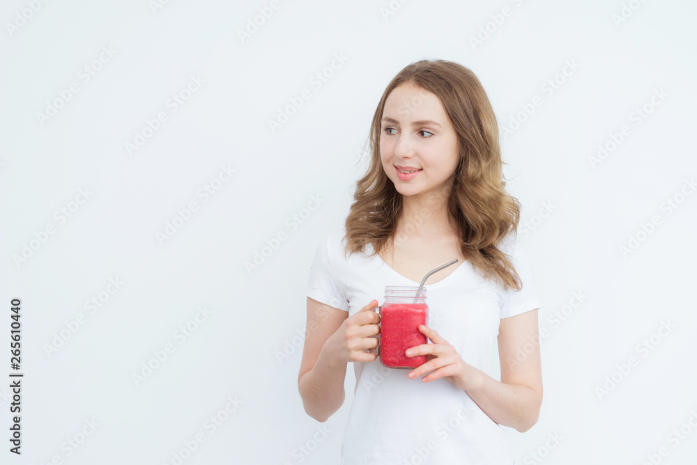 Berry fruit red smoothie in the hands of a young attractive girl on a white background. Berry fruit red smoothie in the hands of a young attractive girl on a white background.
