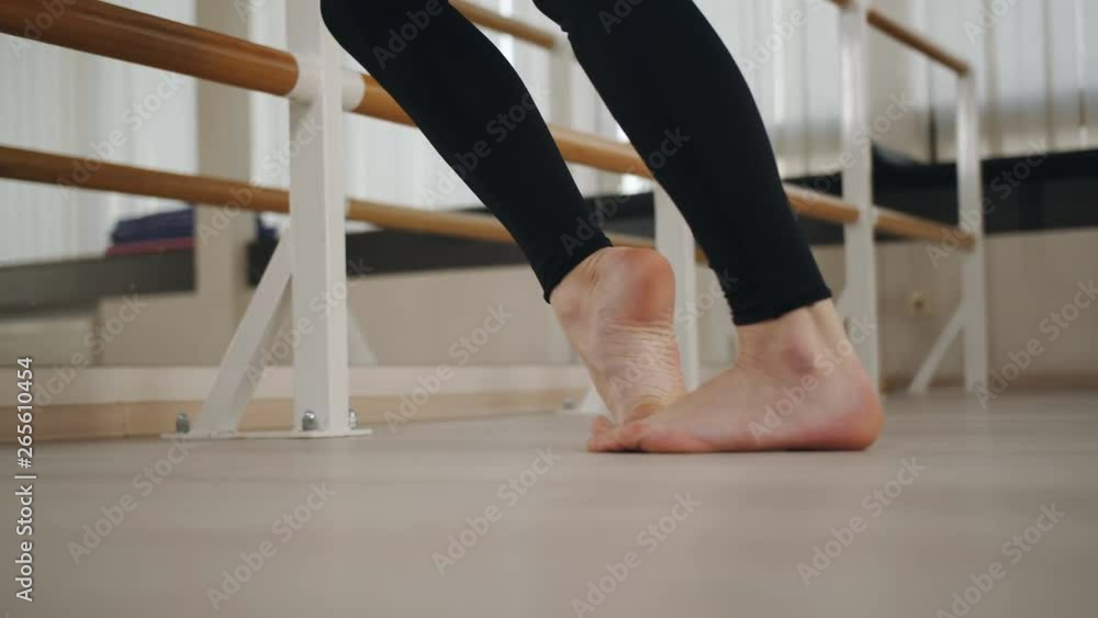 Girl dancer warming up in the ballroom at the ballet bar. Close-up of feet. Girl dancer warming up in the ballroom at the ballet bar. Close-up of feet.