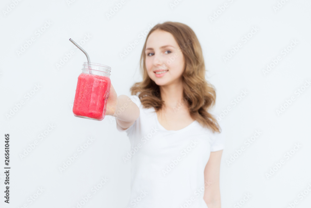 Berry fruit red smoothie in the hands of a young attractive girl on a white background. The concept of healthy eating. Berry fruit red smoothie in the hands of a young attractive girl on a white background. The concept of healthy eating.