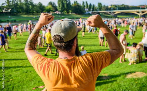 Guy celebrate holiday or festival. Summer fest. Man bearded hipster in front of crowd. Open air concert. Book ticket now. Early bird sale. Music festival. Entertainment concept. Visit summer festival