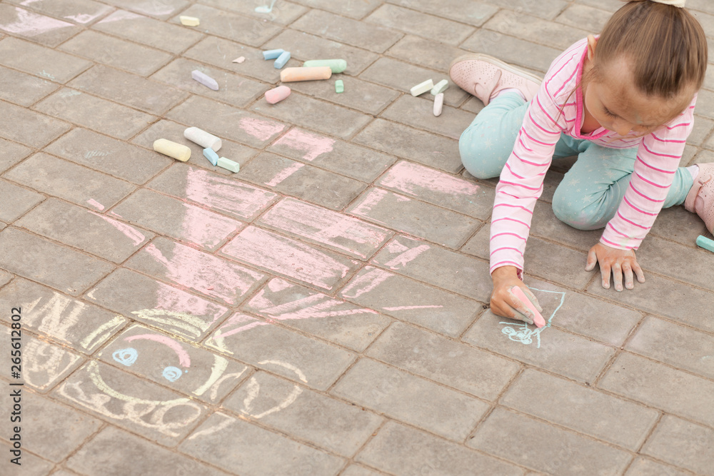 Naklejka premium little girl draws a chalk