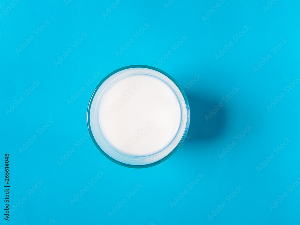 A glass of milk with a blue background A glass of milk with a blue background