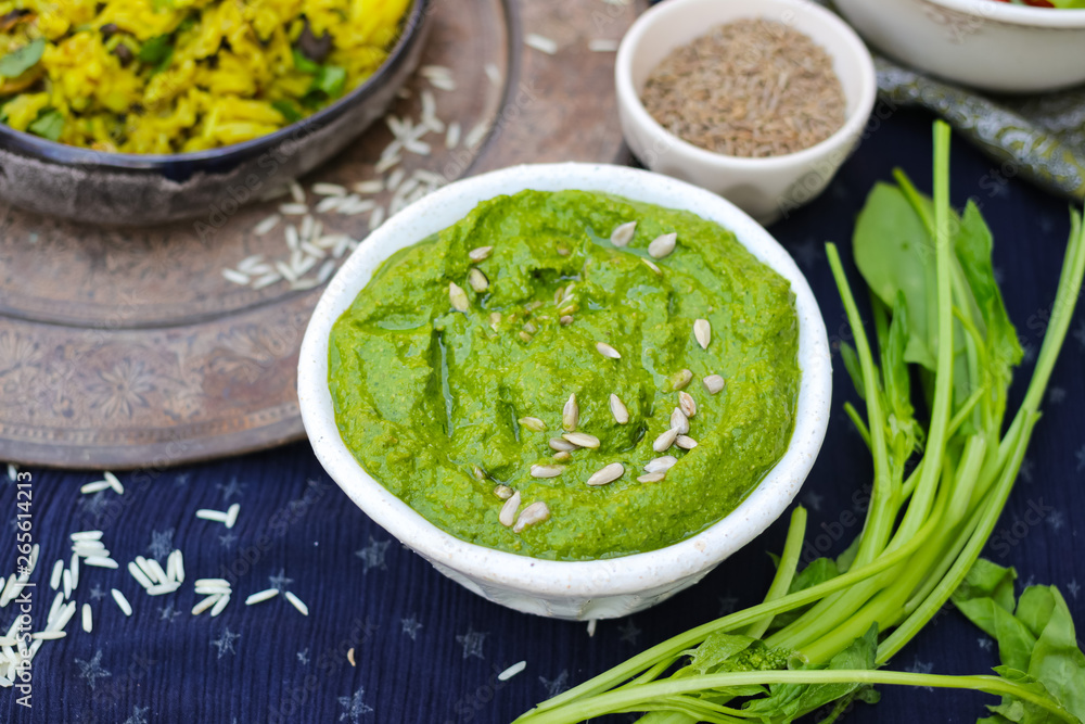 Green spinach dip sauce paste spread in bowl with sunflower seeds, oil and cumin. Organic healthy food snack or appetizer Green spinach dip sauce paste spread in bowl with sunflower seeds, oil and cumin. Organic healthy food snack or appetizer