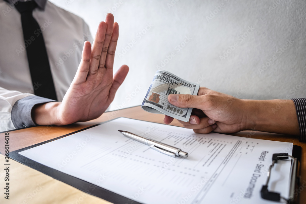 Anti bribery and corruption concept, Business man refusing and don't receive money banknote in envelop offer from business people to accept agreement contract of investment deal Anti bribery and corruption concept, Business man refusing and don't receive money banknote in envelop offer from business people to accept agreement contract of investment deal