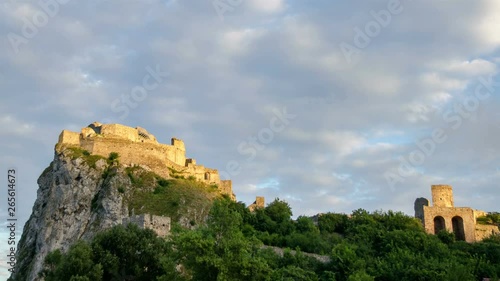 Sunrise clouds sky over historic castle ruins in green forest Time lapse photo