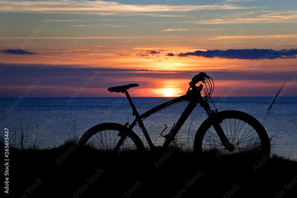 Fototapeta premium beautiful sunset on the sea and the silhouette of a bicycle