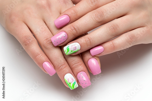  Spring manicure. Pink manicure with painted flowers on short oval nails on a white background.